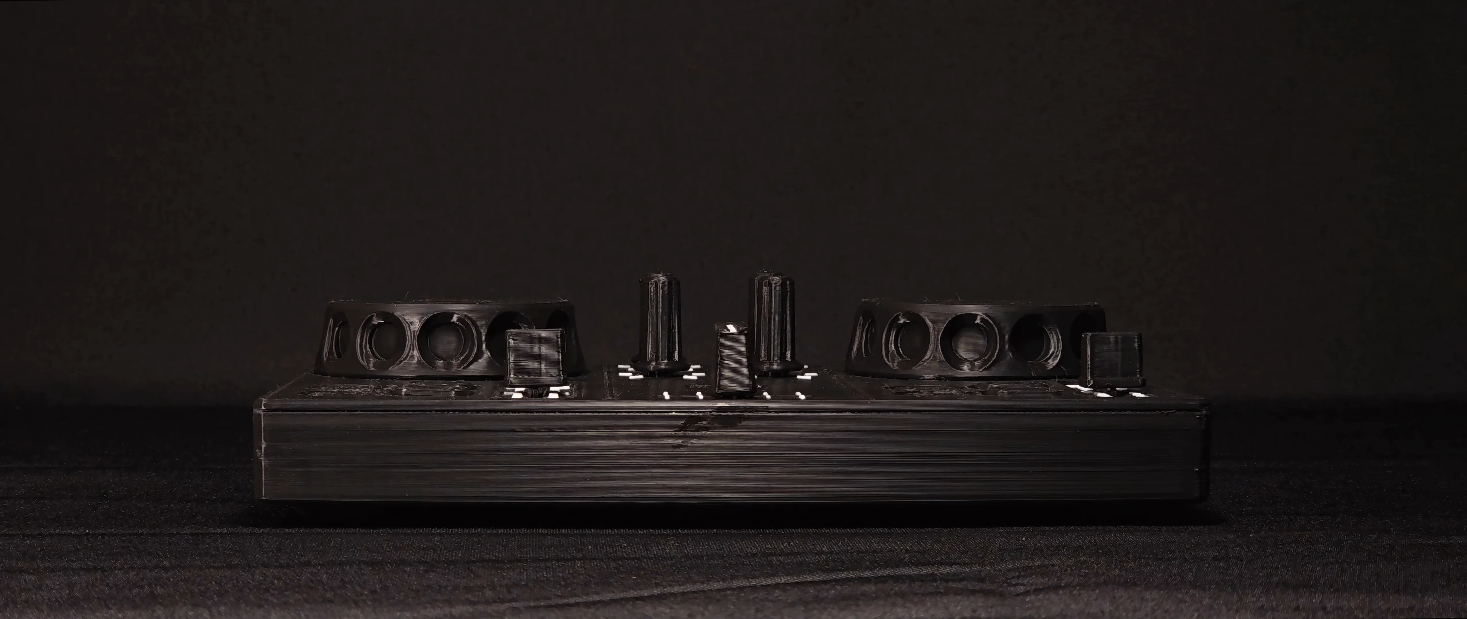 DJC-DIY seen from the front, at desk level, against a dark background