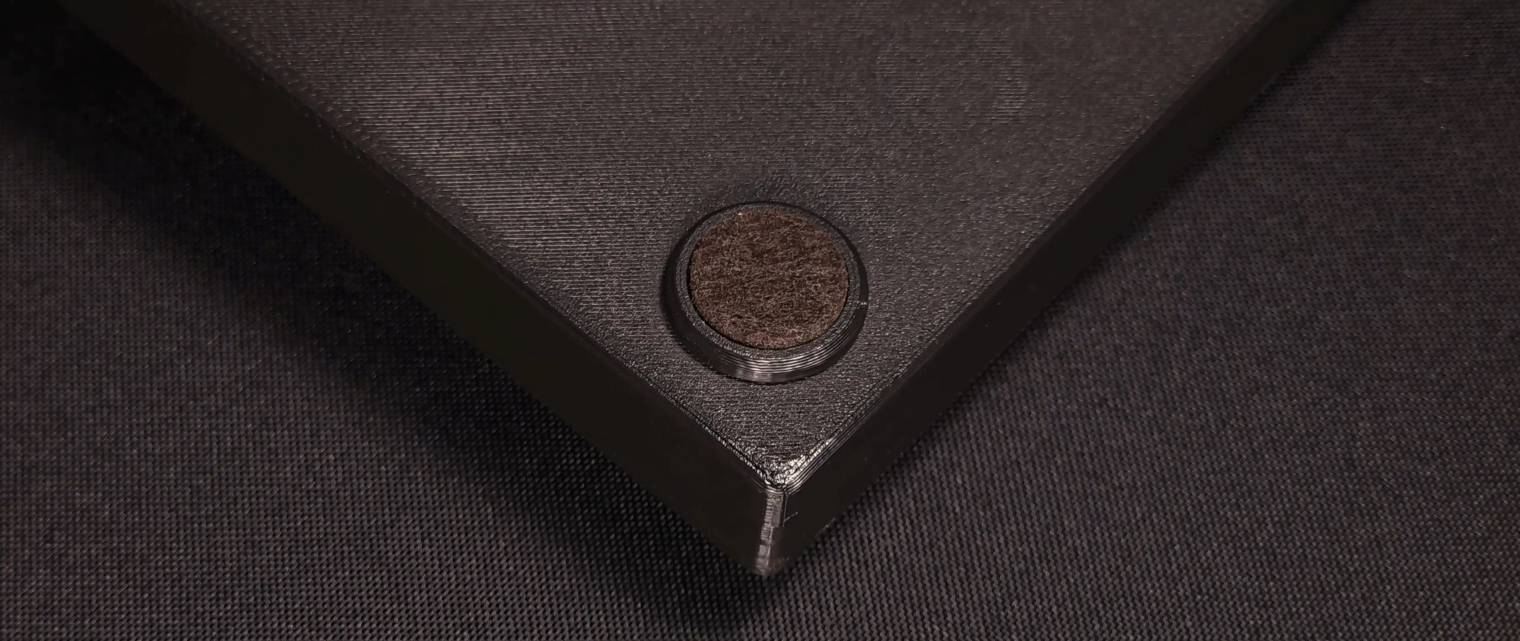 Close-up of a corner of the case, with one of the felt feet underneath