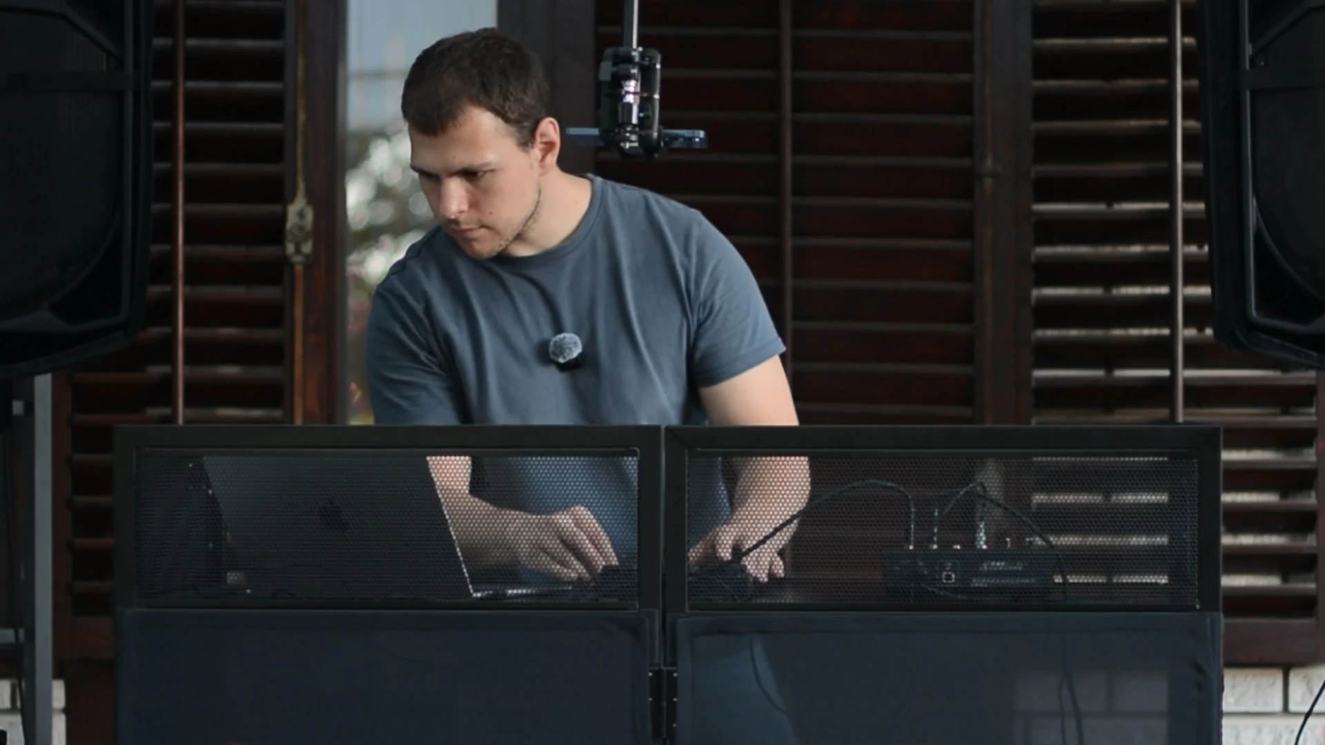DJ Tweety mixing behind a DJ booth, a laptop on one side of him and DJC-DIY on the other